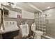 View of a unique basement bathroom with vintage-style sink, water closet and tiled shower at 6471 S Potomac Ct, Englewood, CO 80111