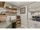 Practical craft room with a workbench, shelving, and access to a comfortable seating area at 6471 S Potomac Ct, Englewood, CO 80111