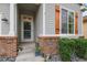 View of the home's front entrance showing a decorative door, gray siding and brick accents at 6471 S Potomac Ct, Englewood, CO 80111