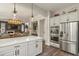 Kitchen featuring stainless steel appliances, white cabinets, quartz countertops, and open floorplan at 6471 S Potomac Ct, Englewood, CO 80111