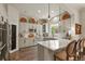 Modern kitchen featuring white cabinets, a center island with seating, and stainless steel appliances at 6471 S Potomac Ct, Englewood, CO 80111