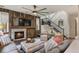 Spacious living room featuring a rustic stone fireplace, comfortable seating, and staircase at 6471 S Potomac Ct, Englewood, CO 80111