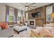 Comfortable living room with natural light, a rustic stone fireplace, and stylish decor at 6471 S Potomac Ct, Englewood, CO 80111