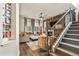 Inviting living room with a stone fireplace, wood-paneled wall, and staircase at 6471 S Potomac Ct, Englewood, CO 80111