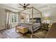 The main bedroom features a wood four-poster bed, ceiling fan, window and paneled accent wall at 6471 S Potomac Ct, Englewood, CO 80111