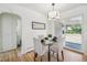 Stylish dining area featuring a glass table set, upholstered chairs, and sliding glass doors to the backyard at 2230 Niagara St, Denver, CO 80207