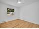 A bright, minimalist bedroom, lit by a ceiling fan and natural light from the single window at 5345 E Thrill Pl, Denver, CO 80207