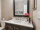 Charming powder room with dark wood vanity, marble countertop, and decorative accents at 570 Clarendon Loop, Castle Pines, CO 80108