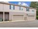 Townhome exterior featuring two garage doors and neutral siding with dark trim at 570 Clarendon Loop, Castle Pines, CO 80108