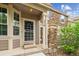 Inviting front entrance with stone accents, manicured landscaping, and a charming entryway at 570 Clarendon Loop, Castle Pines, CO 80108
