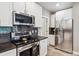 Modern kitchen with stainless steel appliances, tile backsplash, and white cabinetry at 570 Clarendon Loop, Castle Pines, CO 80108
