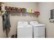 Functional laundry room with washer, dryer, and storage shelves with baskets at 570 Clarendon Loop, Castle Pines, CO 80108