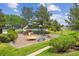 Community playground with slide, green grass, trees, providing a fun and safe area for children to play at 570 Clarendon Loop, Castle Pines, CO 80108