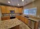 Galley-style kitchen with granite countertops and stainless steel appliances at 18874 E Ida Ave, Aurora, CO 80015