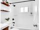 Bright bathroom with updated vanity, tiled shower and tub, black hardware, and decorative shelves at 4201 Shoshone St, Denver, CO 80211