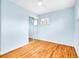 Empty bedroom featuring light blue walls, hardwood floors, lots of light, and a mirrored closet at 4201 Shoshone St, Denver, CO 80211