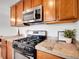 Modern kitchen featuring stainless steel appliances, granite countertops, and wood cabinets at 4201 Shoshone St, Denver, CO 80211