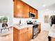 Well-lit kitchen featuring wood cabinets, tile floors, granite countertops, and stainless steel appliances at 4201 Shoshone St, Denver, CO 80211