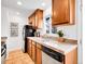 Bright kitchen showcasing wood cabinets, tile floors, granite countertops, and stainless steel appliances at 4201 Shoshone St, Denver, CO 80211