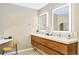 Modern bathroom featuring a double sink vanity with lighted mirrors and stylish patterned flooring at 6681 S Abilene Way, Centennial, CO 80111