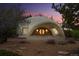 Unique dome home with a stone-accented entryway and distinctive arched porch at twilight at 6681 S Abilene Way, Centennial, CO 80111