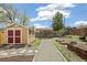 Spacious backyard with a tool shed, hammock, garden beds, and a gravel pathway at 2170 W Warren Ave, Englewood, CO 80110