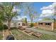 Landscaped backyard featuring an outdoor patio, raised garden beds, a tool shed, and mature trees at 2170 W Warren Ave, Englewood, CO 80110