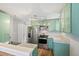 Well-lit kitchen with mint green cabinets, stainless steel appliances, and granite countertops at 2170 W Warren Ave, Englewood, CO 80110