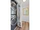 Stacked washer and dryer in hallway laundry closet with mirrored door on closet at 2170 W Warren Ave, Englewood, CO 80110