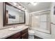 Bathroom featuring a vanity with sink, a large mirror, lighting, and a tiled shower over the bath at 11710 Elk Head Range Rd, Littleton, CO 80127