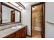 Well-lit bathroom showcasing a single sink vanity, a large mirror, and a glass-enclosed shower at 11710 Elk Head Range Rd, Littleton, CO 80127