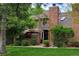 Charming townhome featuring a brick chimney, manicured lawn, and covered front porch at 11710 Elk Head Range Rd, Littleton, CO 80127