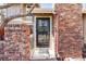 Charming brick facade with secure, decorative iron gate protecting front door at 11710 Elk Head Range Rd, Littleton, CO 80127