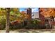 Charming townhome exterior featuring a brick facade with colorful autumn foliage and lush greenery at 11710 Elk Head Range Rd, Littleton, CO 80127