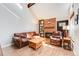 Inviting living room featuring exposed beams, hardwood floors, and a brick fireplace at 11710 Elk Head Range Rd, Littleton, CO 80127