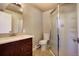 Modern bathroom with granite countertop, wood cabinet, and glass-enclosed shower at 8900 W Hampden Ave, Denver, CO 80227
