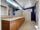 Modern bathroom featuring a long vanity, double sinks, a large mirror, and tiled walk-in shower at 8900 W Hampden Ave, Denver, CO 80227