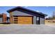 Modern garage with stylish wood door, accent stone and black trim at 8900 W Hampden Ave, Denver, CO 80227