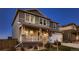 Two-story home showcasing a covered front porch, two-car garage, and well-maintained landscaping in the front yard at 17203 Birds Foot Ave, Parker, CO 80134