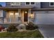 Close up of front entrance featuring stone accents on the columns and front face of the home and a well manicured front lawn at 17203 Birds Foot Ave, Parker, CO 80134