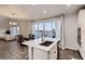 Modern open-concept kitchen featuring an island, stainless steel appliances, and adjacent dining area with deck access at 17203 Birds Foot Ave, Parker, CO 80134