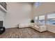 Bright living room with a large sectional sofa, wood floors, and soaring ceilings with many windows allowing ample natural light at 17203 Birds Foot Ave, Parker, CO 80134