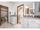 Elegant bathroom with double vanity sinks, decorative mirrors, and tiled floors with two doorways at 1324 Shadow Mountain Dr, Highlands Ranch, CO 80126