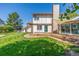 Exterior shot of the home showing the deck, manicured lawn, and partial brick facade at 1324 Shadow Mountain Dr, Highlands Ranch, CO 80126
