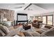 Open living room with wood floors, stone fireplace, a large media screen, and comfortable furniture at 1324 Shadow Mountain Dr, Highlands Ranch, CO 80126