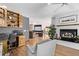 Cozy living room boasts a fireplace, built-in shelves, and a view into the adjoined open-concept living spaces at 1324 Shadow Mountain Dr, Highlands Ranch, CO 80126