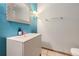 Modern bathroom with teal walls, white vanity, and updated fixtures at 11275 Ranch Pl, Denver, CO 80234