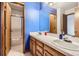 Bathroom with double sinks, wood cabinets, and a shower/tub combo at 11275 Ranch Pl, Denver, CO 80234