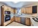 Kitchen with light wood cabinets, stainless steel dishwasher, and tile floor at 11275 Ranch Pl, Denver, CO 80234