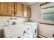 Laundry room with washer, dryer, and upper cabinets at 11275 Ranch Pl, Denver, CO 80234